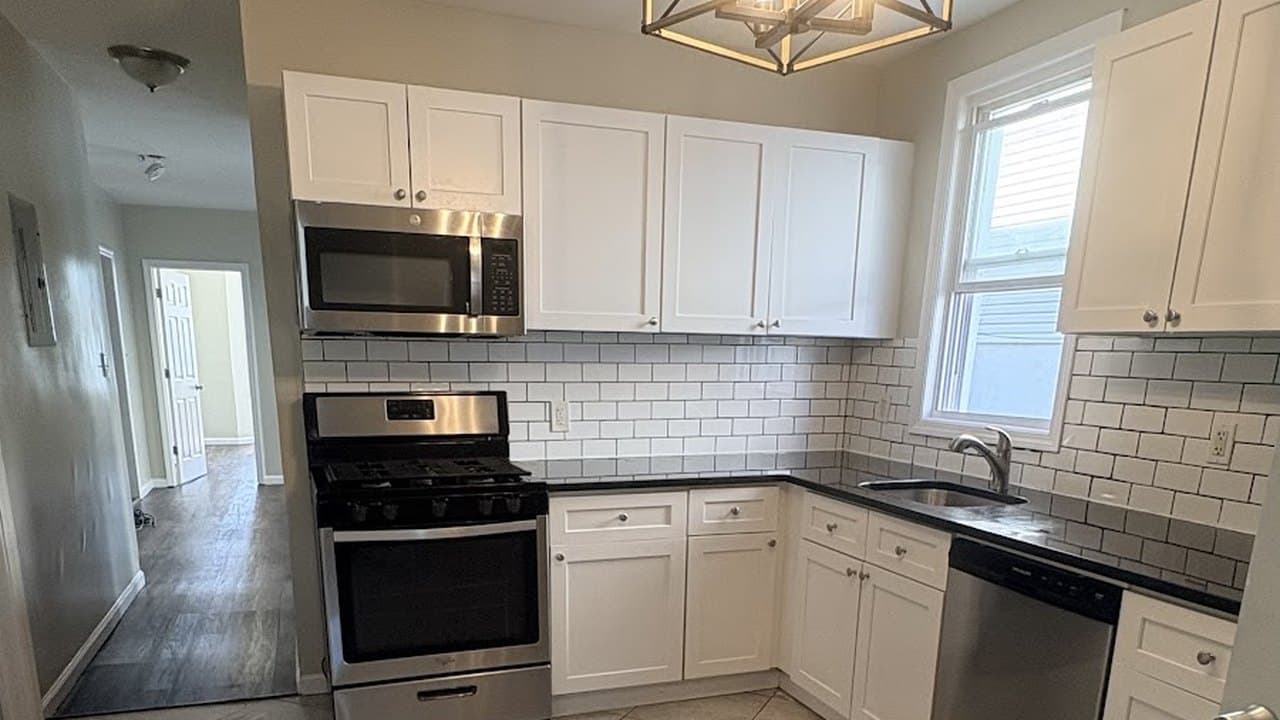 Clean kitchen with subway tile backsplash and stainless appliances